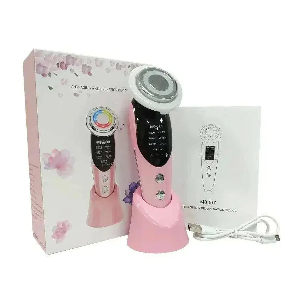 Pink EMS face lifting device with LED therapy, microcurrent functions, charging stand, and USB cable next to packaging box and user manual.