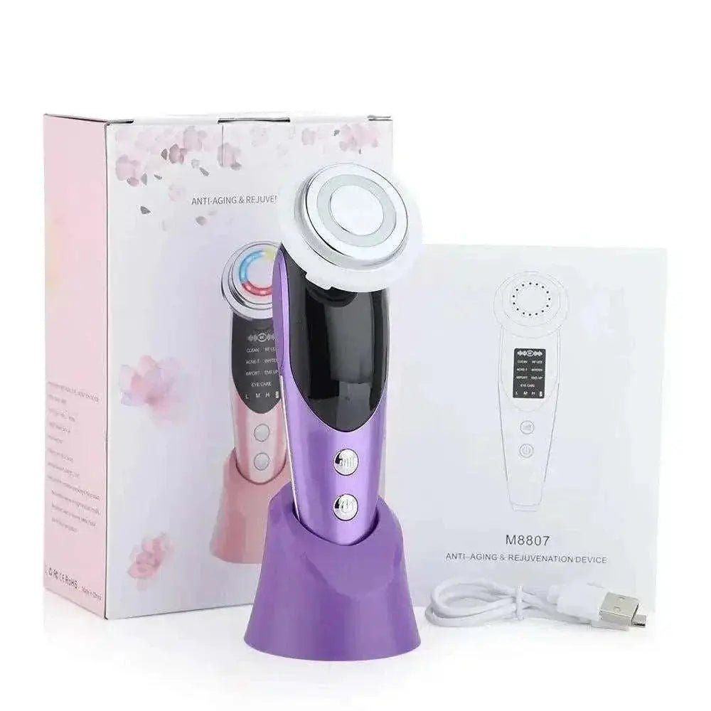 Purple EMS Face Lifting Device with LED therapy and microcurrent, shown with its charging stand, USB cable, user manual, and pink packaging box for anti-aging and skin rejuvenation.