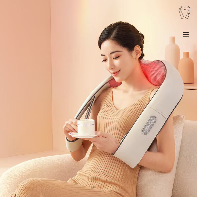 Woman using neck and shoulder massager with heat and Shiatsu kneading while sitting and holding a cup