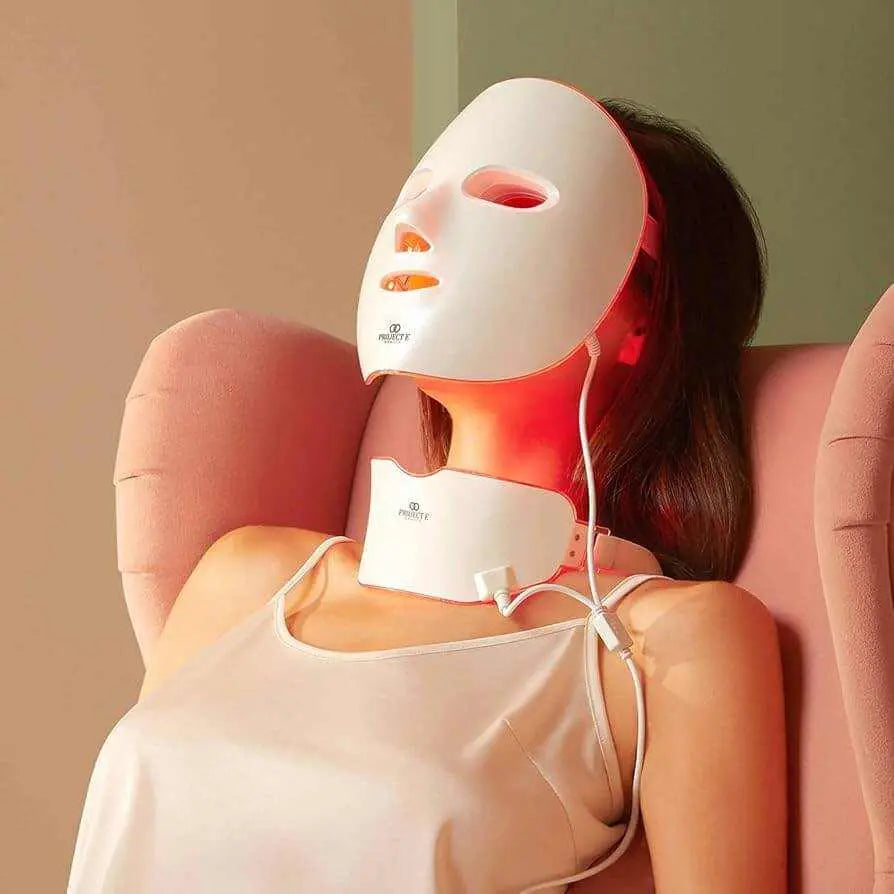 Woman using Wireless LED Light Therapy Mask with 7 color lights for face and neck skin treatment